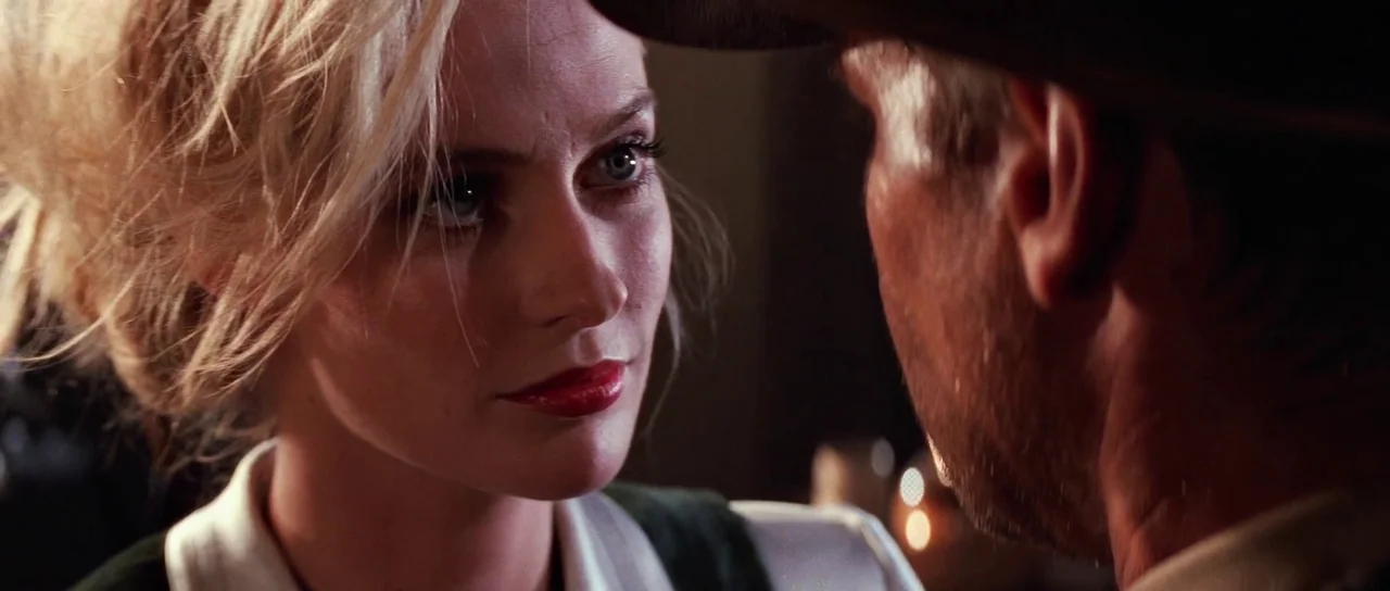 Indiana Jones and the Last Crusade (1989) movie still: closeup — An interior space with dim, warm ambient lighting suggesting a dark, crowded bar…