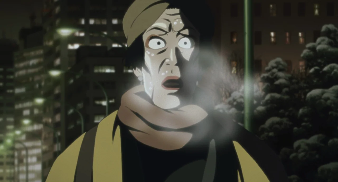 Tokyo Godfathers (2003) movie still: closeup — An urban city street at night with blurry building lights in the background. An elderly woman stands…