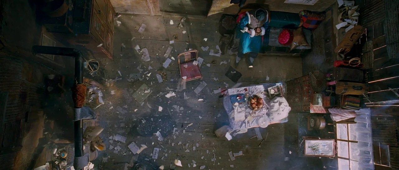 The Good The Bad The Weird (2008) movie still: wide — A cluttered room with wood floors covered in scattered paper and broken debris fragments. An…
