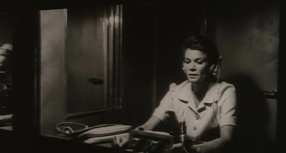 Footprints (Le Orme) (1975) movie still: medium — A dark, cramped space containing a console with audio equipment and a glass partition. A woman…