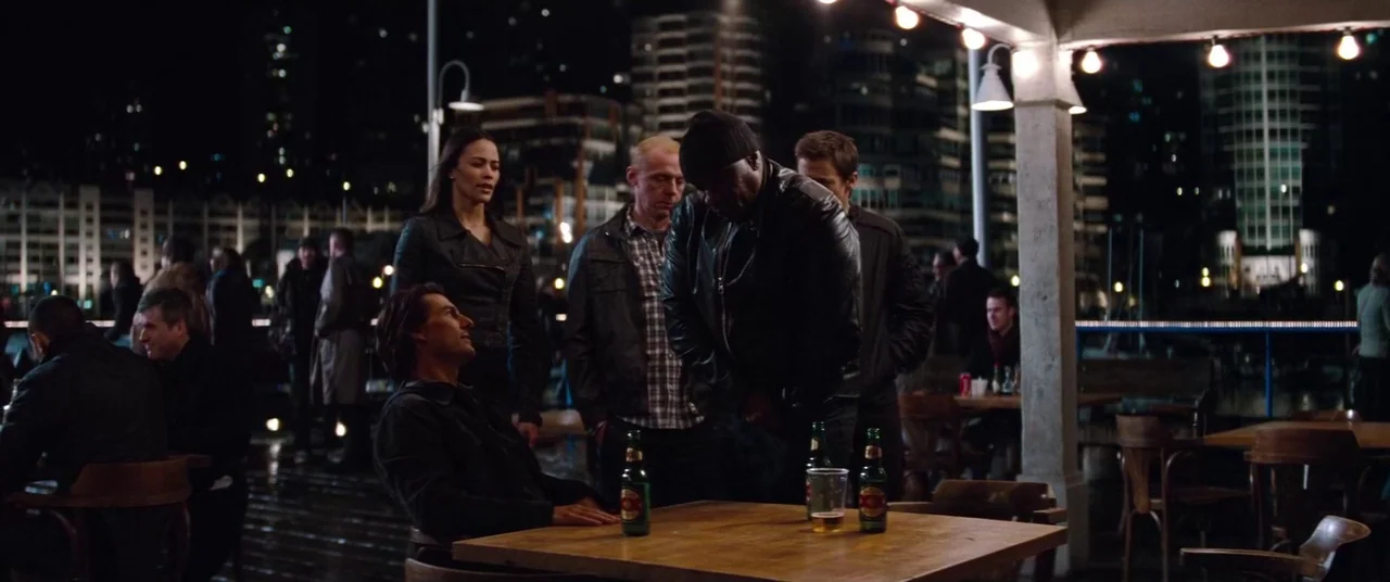 Mission: Impossible – Ghost Protocol (2011) movie still: wide — An outdoor deck by the water at night featuring tables and a covered pavilion. A…