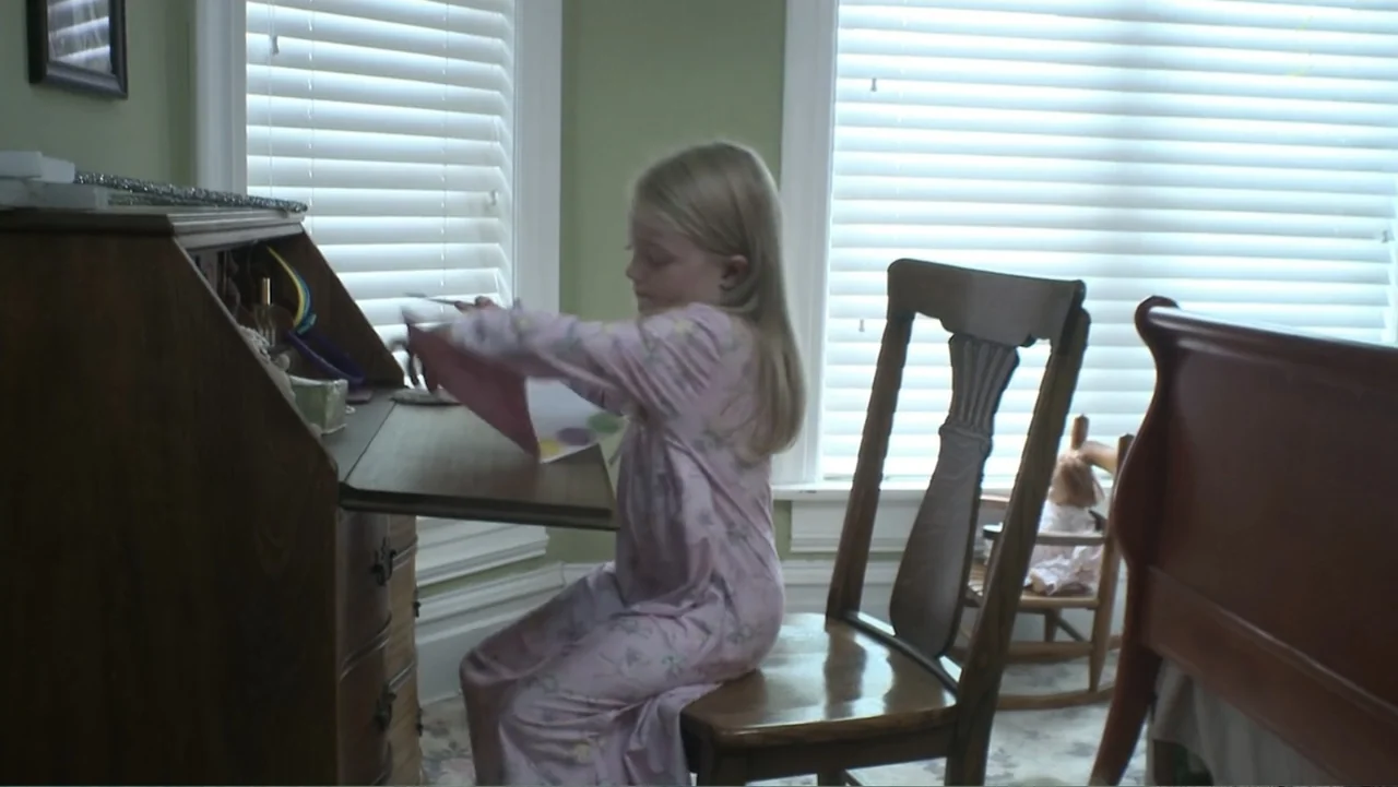 Boathouse Detectives (2010) movie still: medium — A quiet child's bedroom features a dark wood roll-top desk and a matching chair. A young girl in…