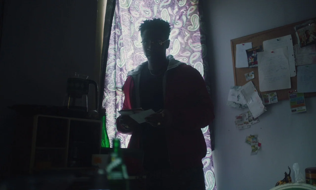 The Last Black Man in San Francisco (2019) movie still: medium — A small indoor space features a wall with a cork bulletin board covered in papers.…