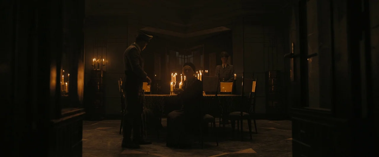 The Hunger Games: The Ballad of Songbirds & Snakes (2023) movie still: wide — A dark dining room features a central table adorned with numerous…