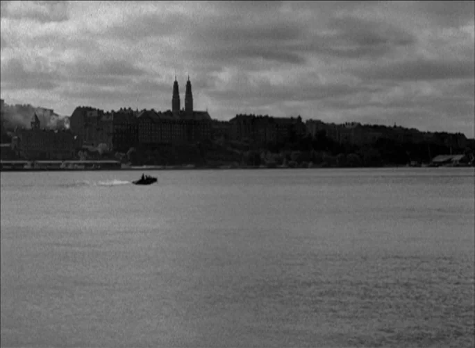 Summer with Monika (1953) movie still: establishing — A wide view of a large body of water beneath an overcast cloudy sky. In the background a…