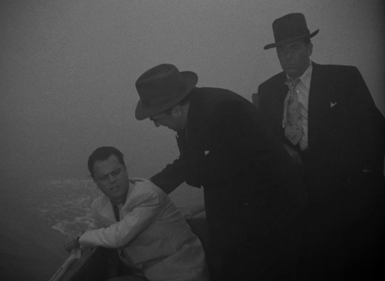 Key Largo (1948) movie still: medium — Three men are on the deck of a boat surrounded by thick heavy fog. Two men in suits and fedoras loom over a…