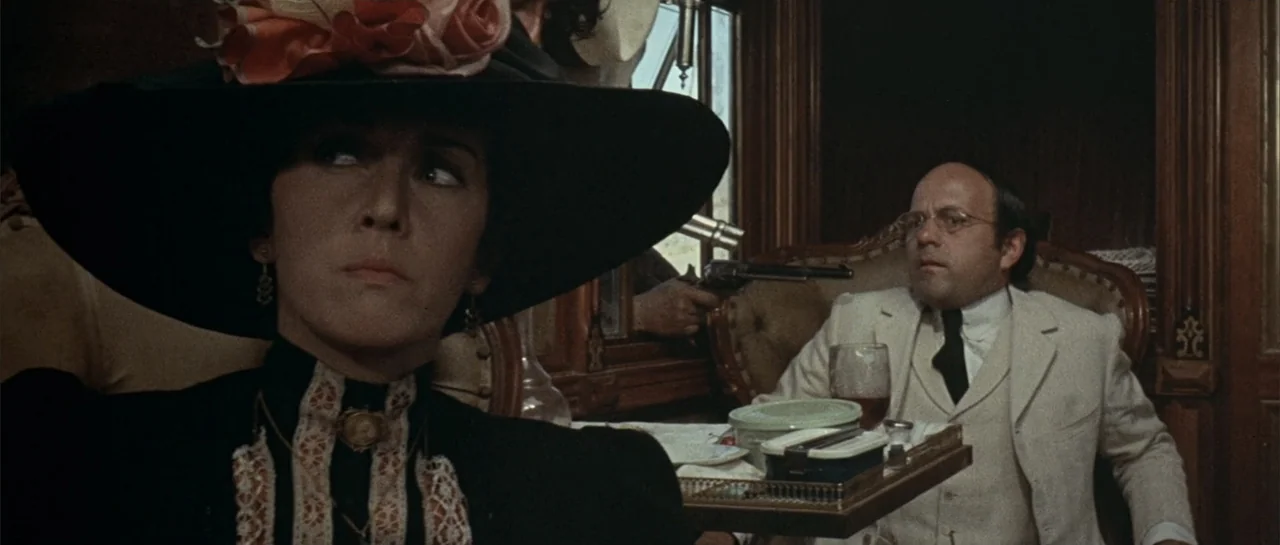 Duck, You Sucker (1971) movie still: medium — A refined, wood-paneled passenger train compartment features ornate seating and table service. A woman…