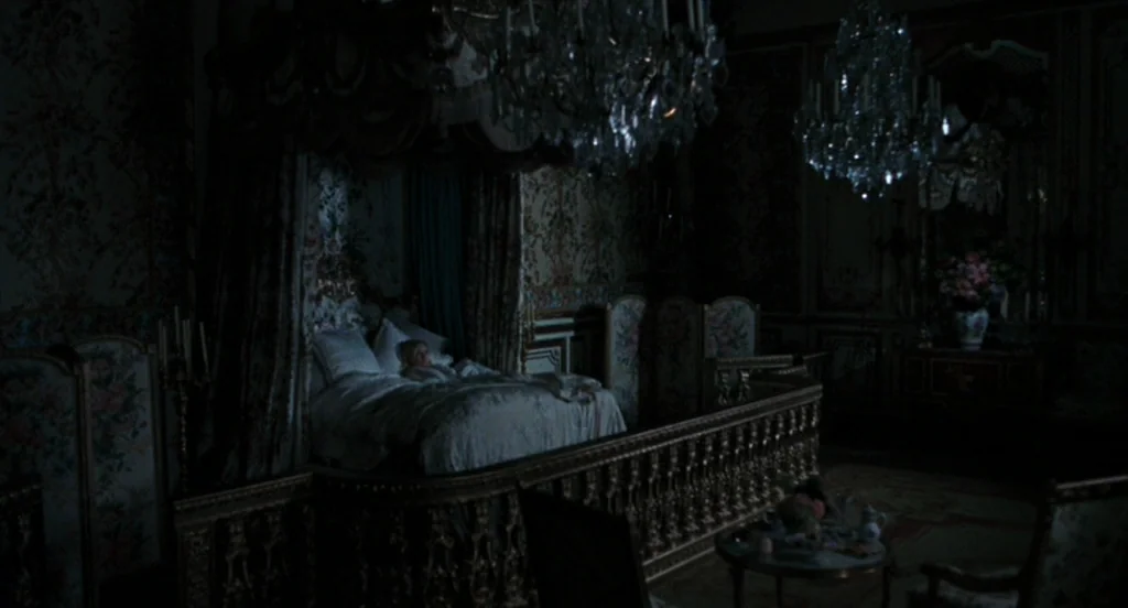 Marie Antoinette (2006) movie still: wide — An ornate room features a large bed with a canopy surrounded by gilded woodwork. A child sleeps under…