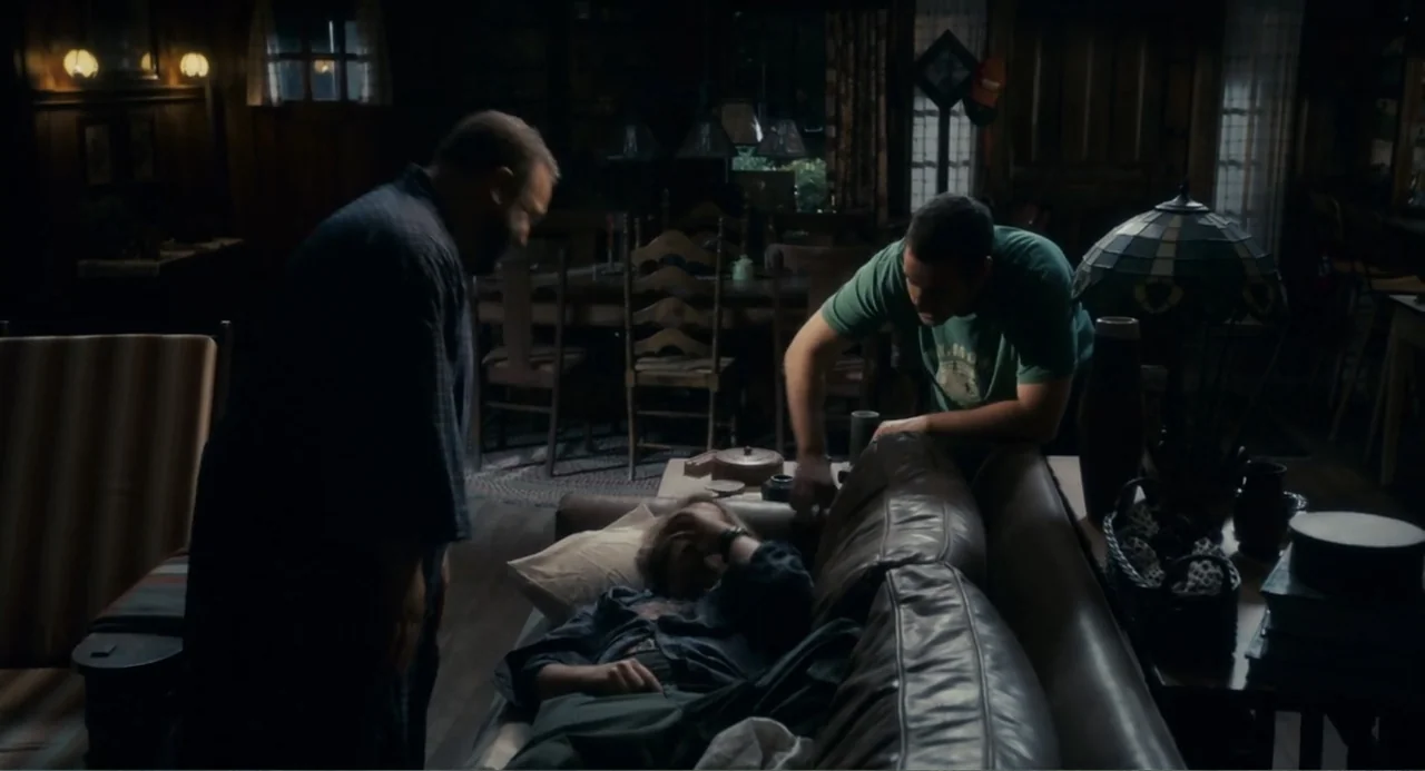 Grown Ups (2010) movie still: medium — A dimly lit room features wood-paneled walls and a traditional table setting behind. Three men occupy the…