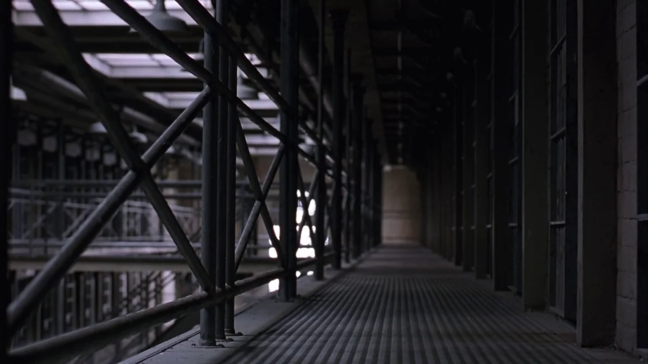 The Shawshank Redemption (1994) movie still: establishing — A long, narrow metal catwalk stretches through a multi-tiered prison cell block…