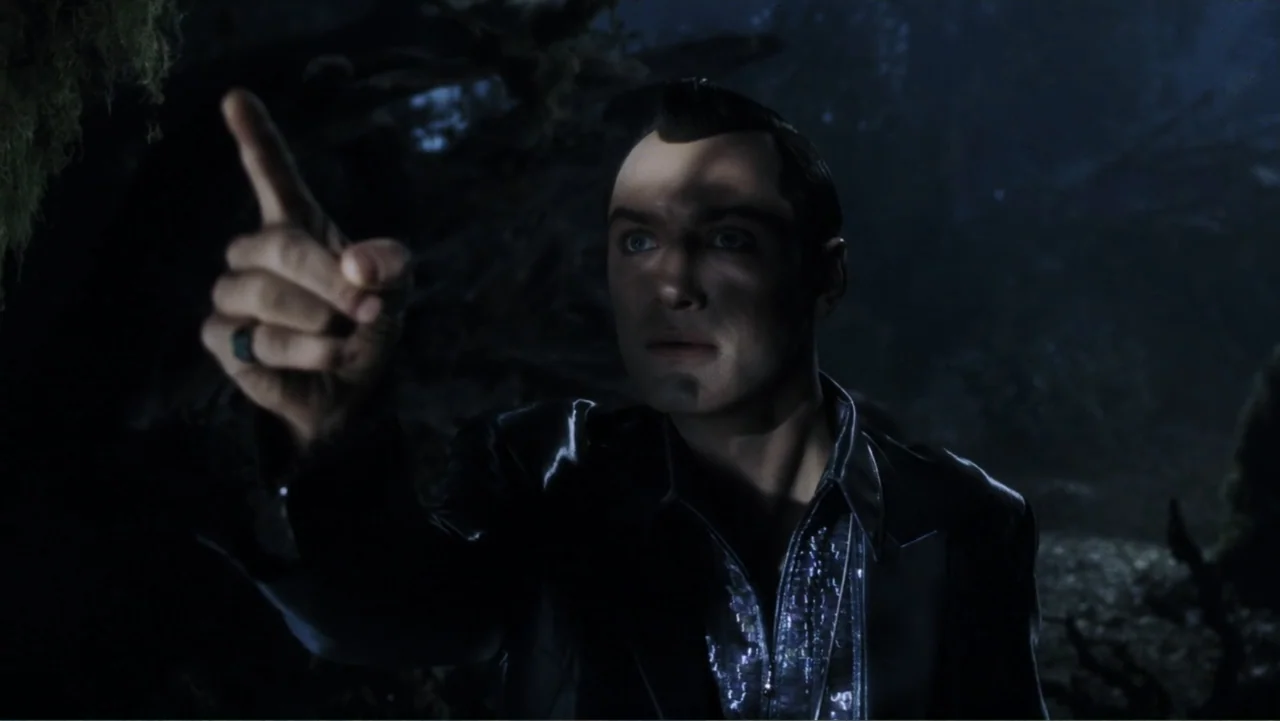 A.I. Artificial Intelligence (2001) movie still: medium — A dark environment filled with foliage and shadowy branches at night. A man with short…