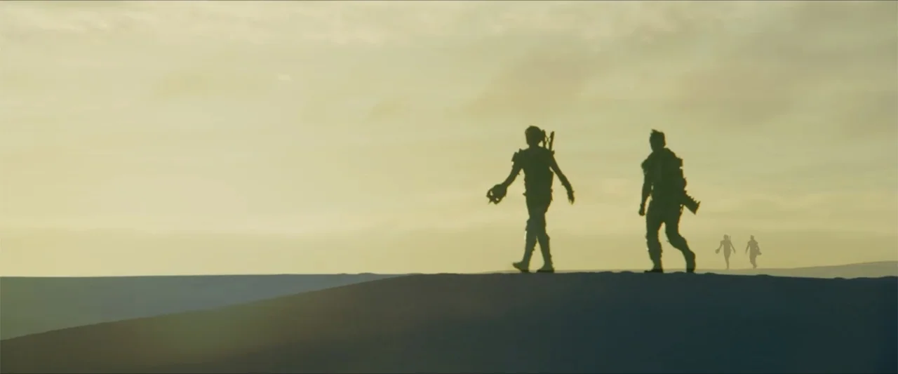 Monster Hunter (2020) movie still: wide — A vast sandy dune under a hazy sunset sky with four silhouettes walking. Two figures lead while two…