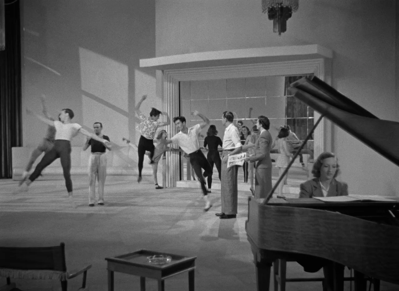 Dance, Girl, Dance (1940) movie still: wide — A spacious dance practice room features large mirrors and a central grand piano. Several dancers…