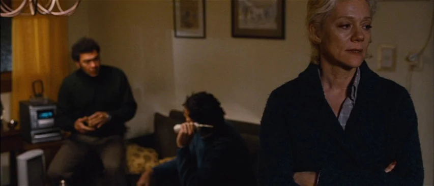The Headless Woman (2008) movie still: medium — A domestic space features walls with framed artwork and a couch in the background. A woman stands in…