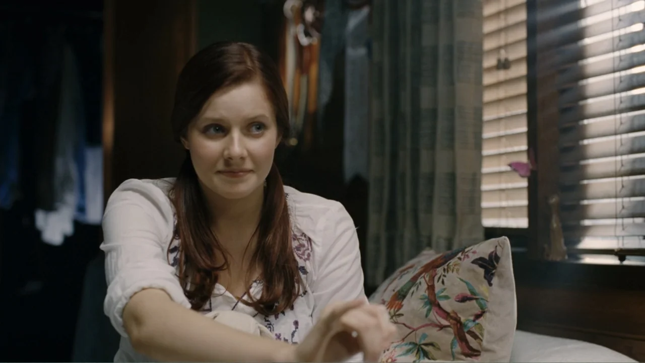 Tomorrow, When the War Began (2010) movie still: medium — A furnished interior bedroom with window blinds casting lines of light across the bed. A…