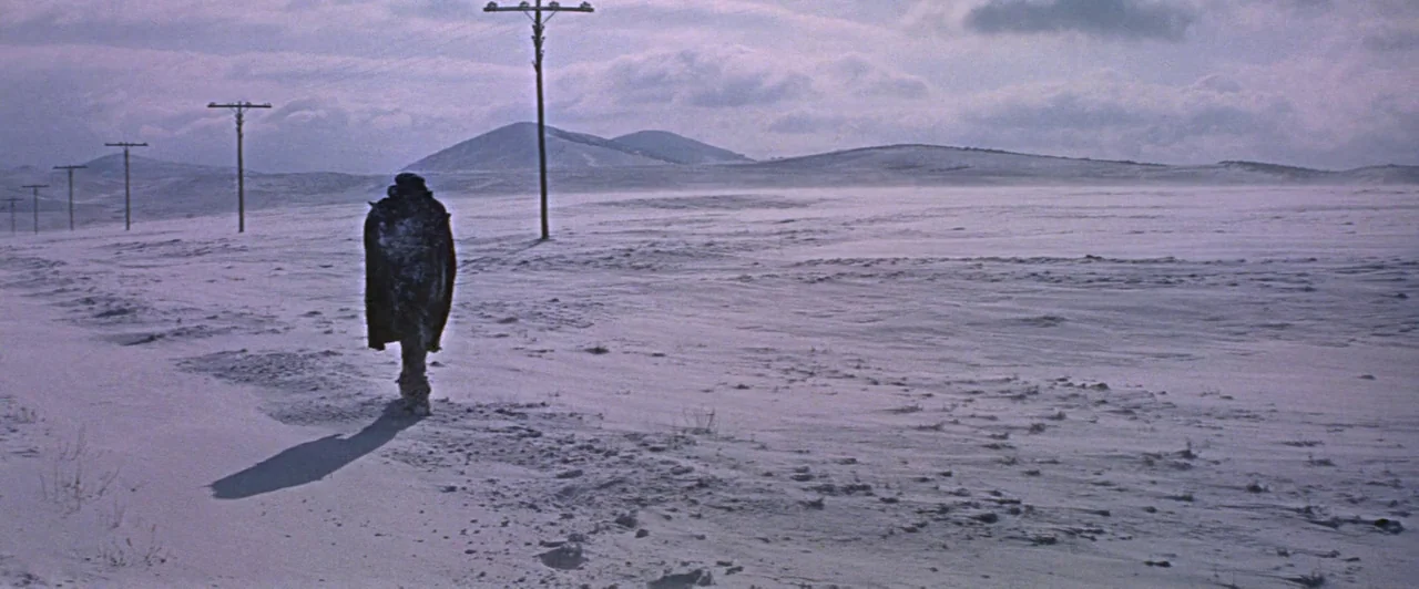 Doctor Zhivago (1965) movie still: wide — A vast, flat snowy plain stretches toward distant low hills under a cloudy sky. A solitary person in dark…
