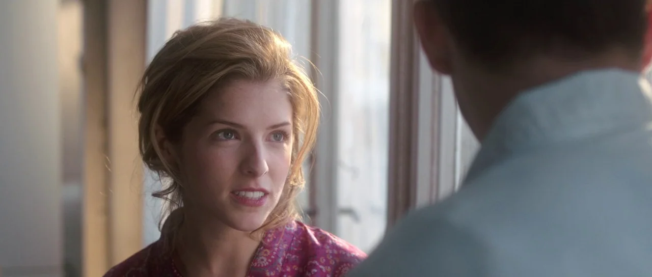 The Voices (2014) movie still: closeup — A bright indoor space features a large window with white frame trim. A young woman talks while facing an…