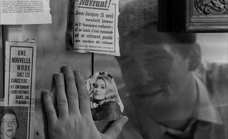 Le Feu Follet (1963) movie still: closeup — A glass display case features various clipped French newspaper articles pasted onto the surface. A young…