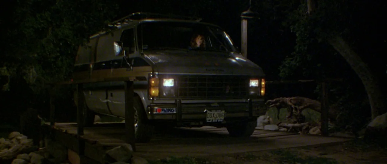 Friday the 13th Part III (1982) movie still: wide — A dark outdoor setting at night features a weathered wooden bridge in a forest. A full-size…