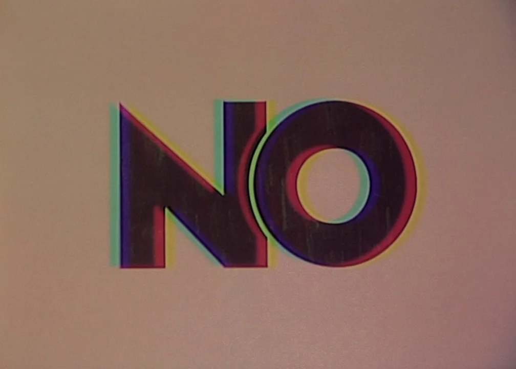 No (2012) movie still: closeup — A plain light beige background featuring centered black typography spelling the word NO. The letters exhibit…