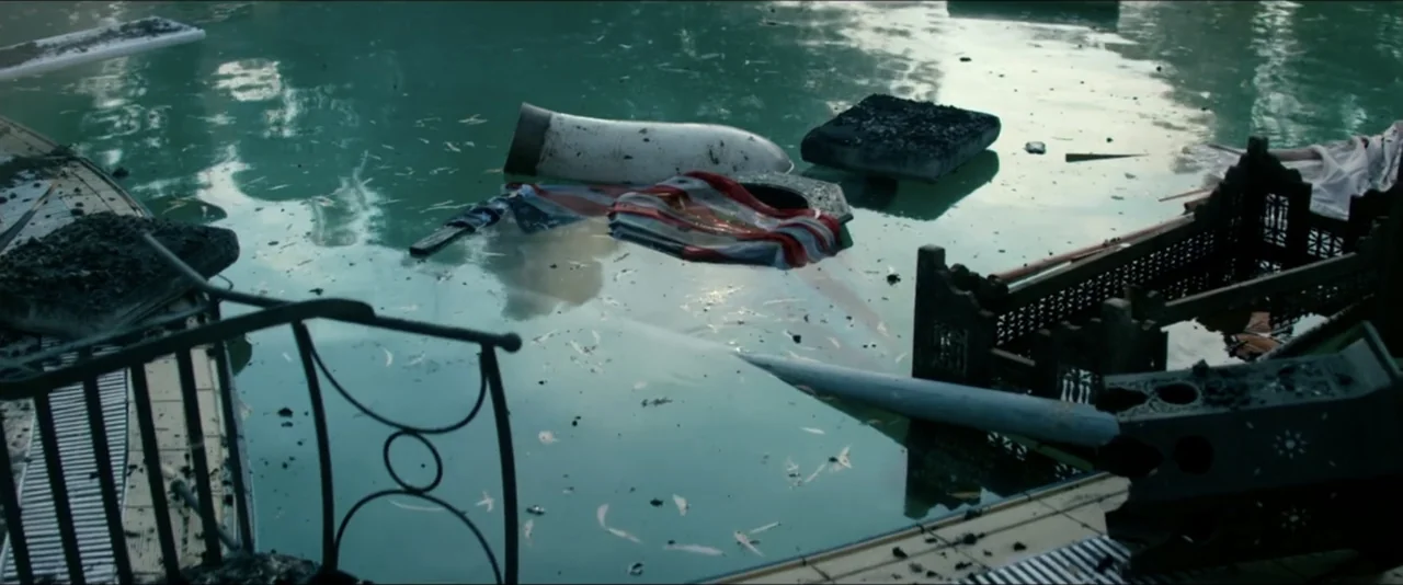 13 Hours: The Secret Soldiers of Benghazi (2016) movie still: establishing — A backyard swimming pool contains floating charcoal-covered debris and…