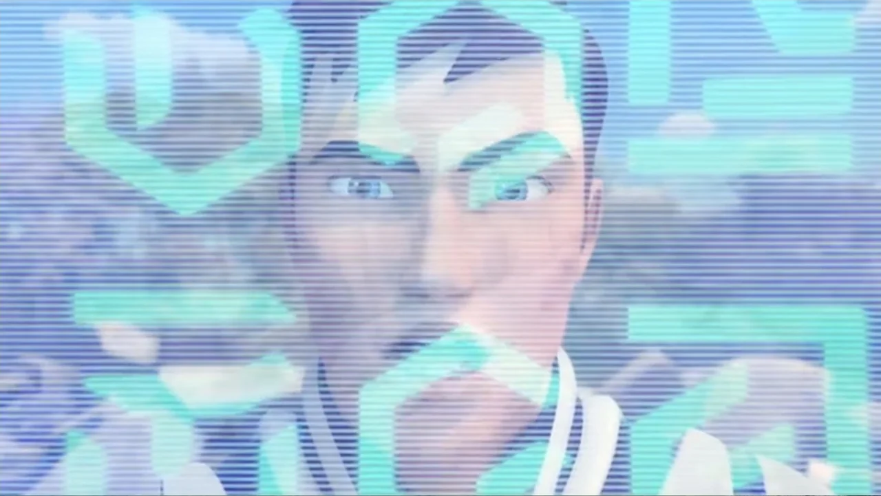Max Steel: Team Turbo (2016) movie still: closeup — A close up view of a digital interface screen with cyan geometric patterns. A young male face is…