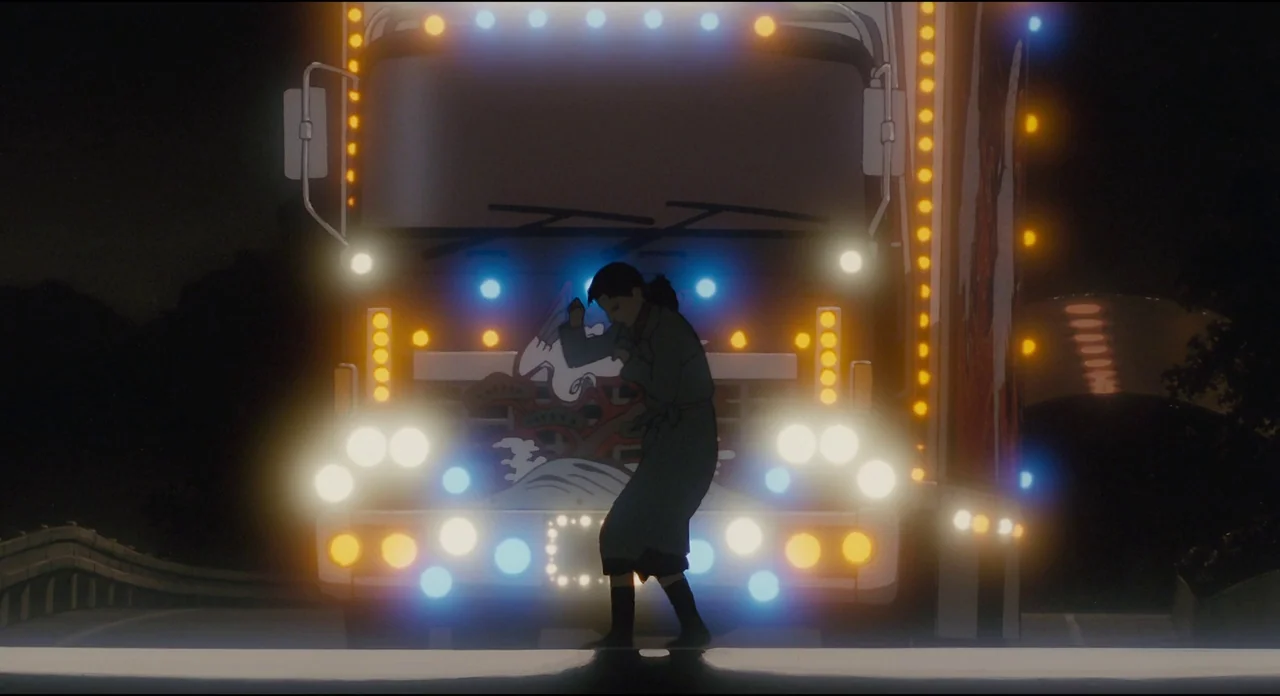 Millenium Actress (2001) movie still: fullbody — A dark road at night features a large truck with elaborate decorative light panels. A lone woman…