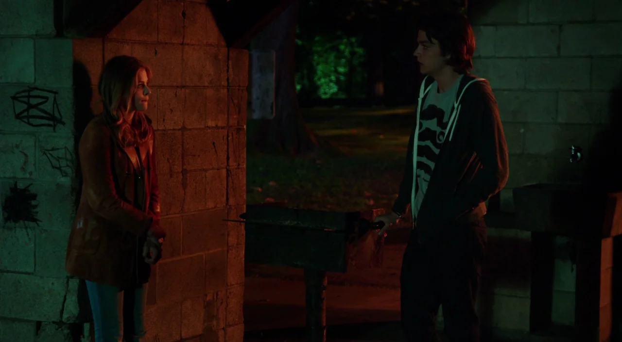 Laggies (2014) movie still: fullbody — A stone pavilion at night with graffiti on the walls and a pedestal grill. The man stands by the grill while…