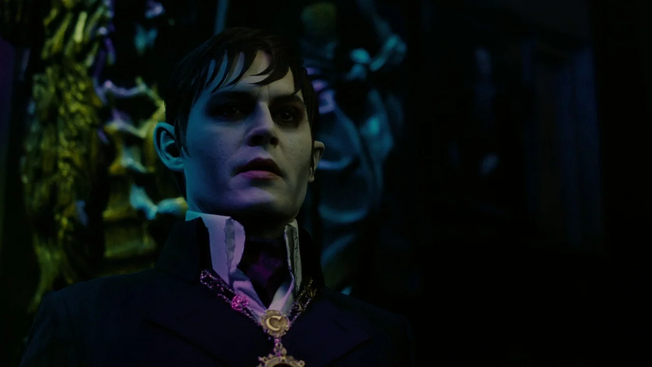 Dark Shadows (2012) movie still: medium — A dimly lit room with ornate, dark architectural details visible in the deep background. A man with pale…