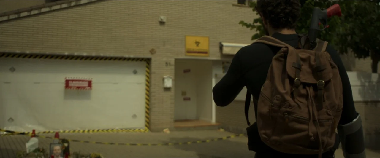 Apocalypse Z: The Beginning of the End (2024) movie still: medium — A tan brick residential house displays a yellow biohazard sign and a white garage.