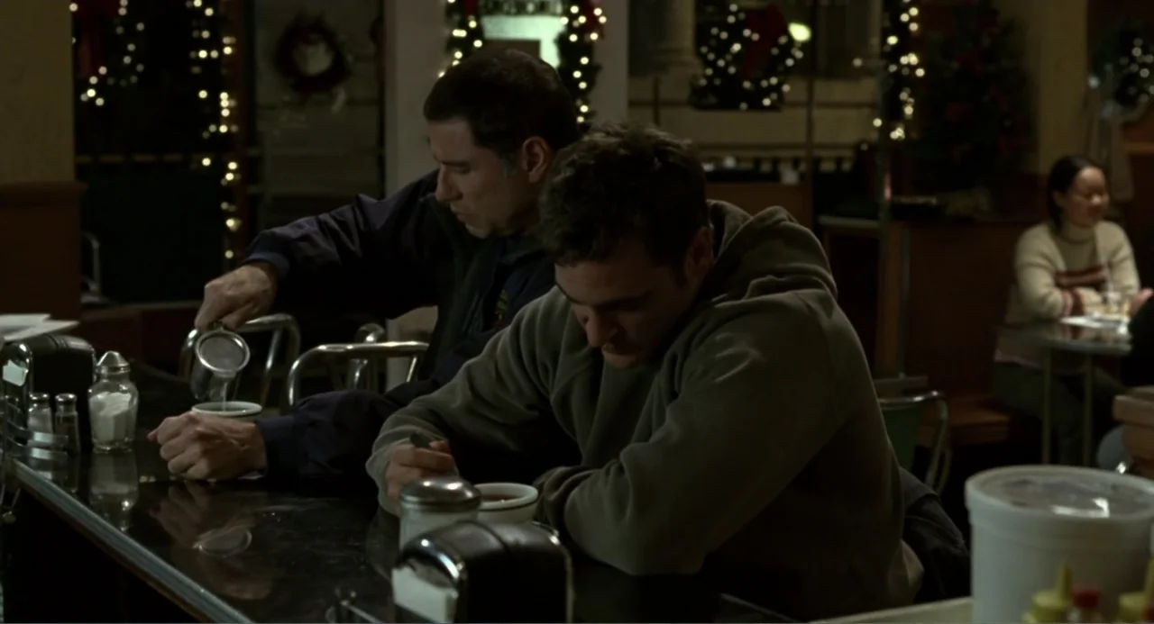 Ladder 49 (2004) movie still: medium — A dimly lit diner interior features a dark counter and seasonal holiday decorations. Two men sit at the…