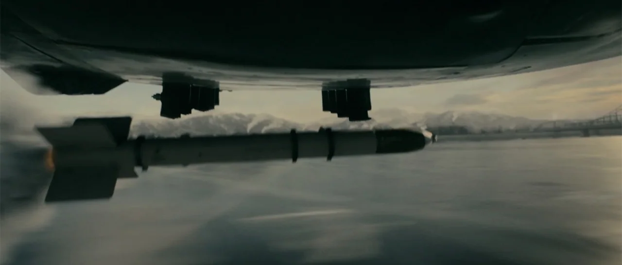 Battle of the Bulge (1965) movie still: wide — An aerial view shows a missile attached to the wing of an aircraft. Snowy mountains and a large…