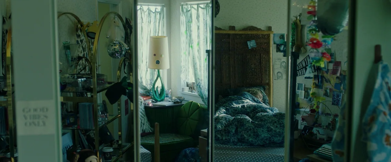 Spontaneous (2020) movie still: medium — A cluttered teen girl's bedroom features patterned wallpaper, gold-framed shelving, and sheer window…