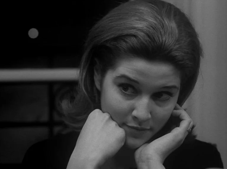 Masculin Féminin (1966) movie still: closeup — A dimly lit room provides a dark, out-of-focus background for the subject. A woman leans her head on…