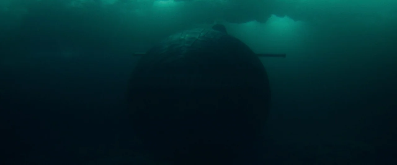 Mission: Impossible – Dead Reckoning Part One (2023) movie still: wide — A dark, spherical vessel is submerged in the deep, opaque teal water of the…