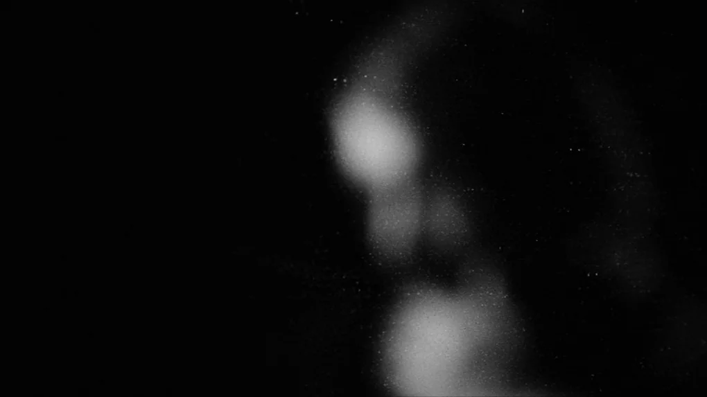 The Role (2013) movie still: closeup — A dark, out-of-focus background displays subtle variations in light intensity. No identifiable subjects or…