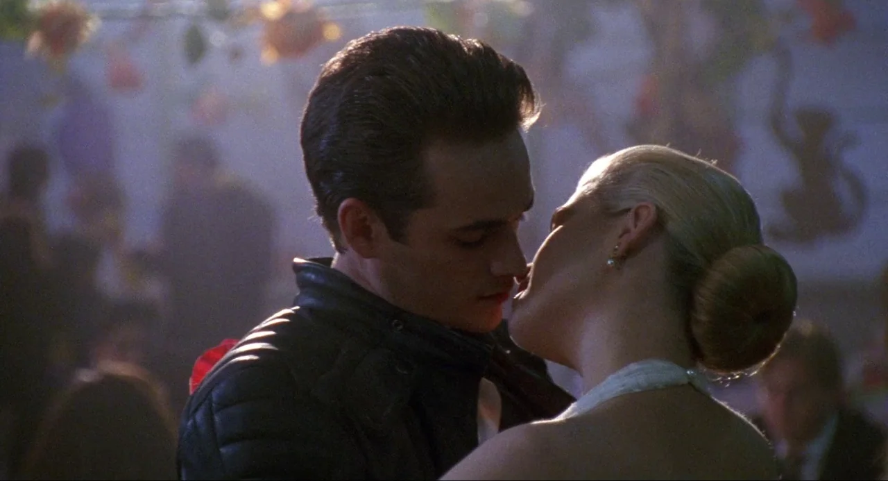 Buffy the Vampire Slayer (1992) movie still: medium — A dark, dimly lit gymnasium interior features decorative hanging banners in the blurred…