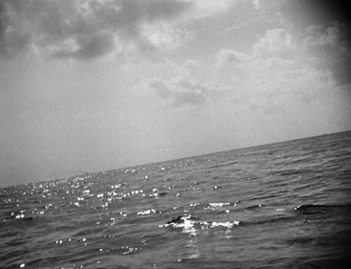 The White Sheik (1952) movie still: establishing — A vast expanse of ocean is captured from a low, tilted angle at sea level. Fluffy clouds drift…