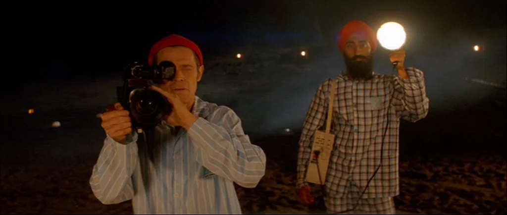 The Life Aquatic With Steve Zissou (2004) movie still: medium — A dark, sandy beach at night illuminated by a single handheld light source. Two men…