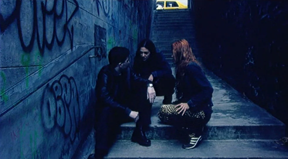 Scarlet Diva (2000) movie still: wide — A concrete underpass features graffiti-covered walls and a wide staircase leading upward into darkness.…