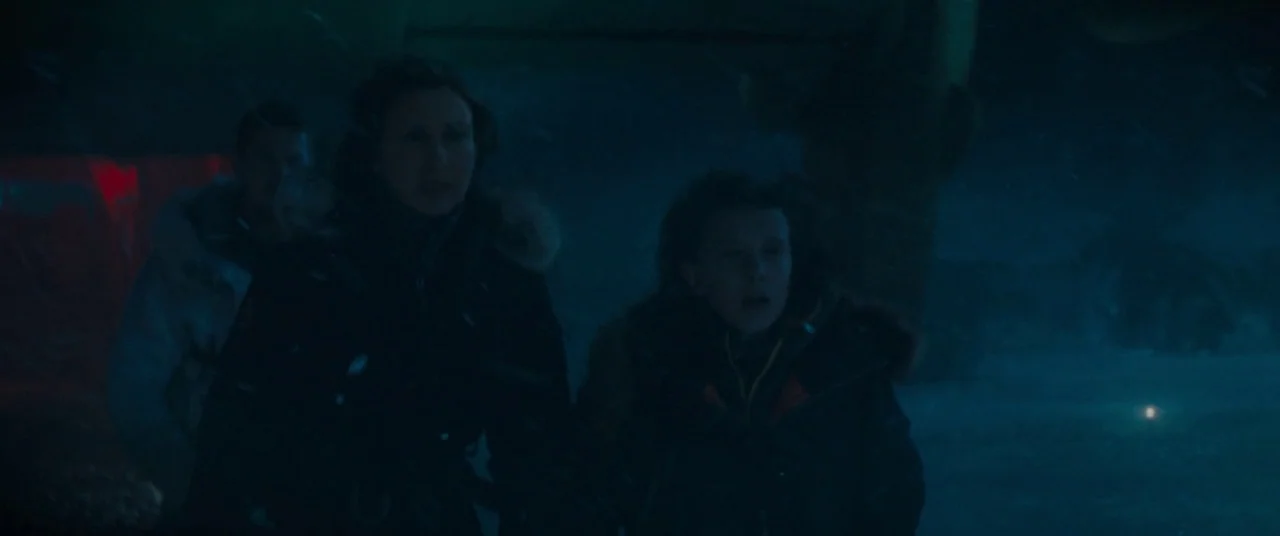 Godzilla: King of the Monsters (2019) movie still: medium — A dark arctic landscape at night with falling snow obscures the surroundings. Two women…