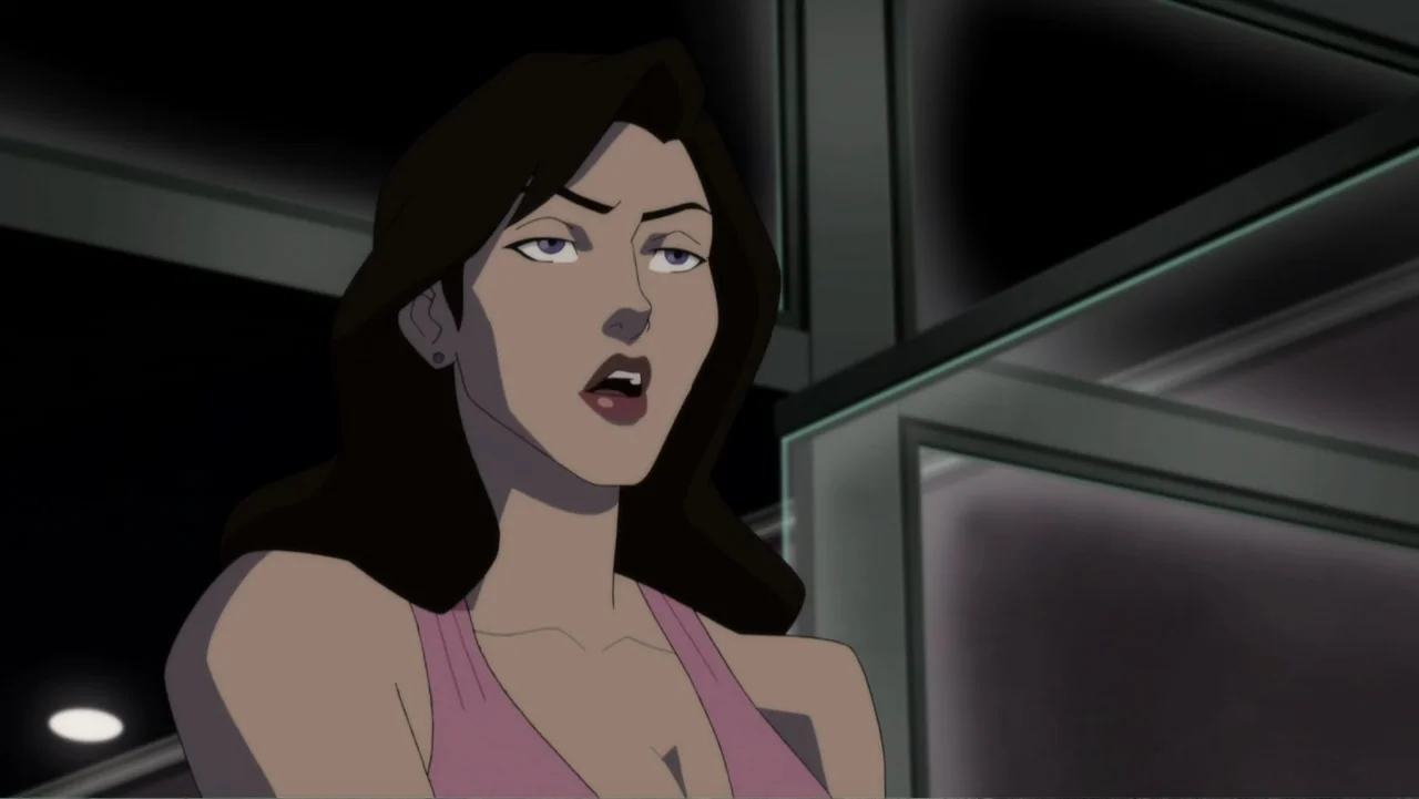Reign of the Supermen (2019) movie still: closeup — A dark interior with structured metal beams and glass surfaces in the background. A woman in a…