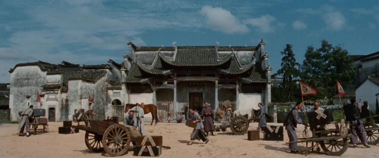 Crouching Tiger, Hidden Dragon (2000) movie still: wide — A traditional Chinese courtyard with whitewashed walls and a tiled gatehouse under blue…