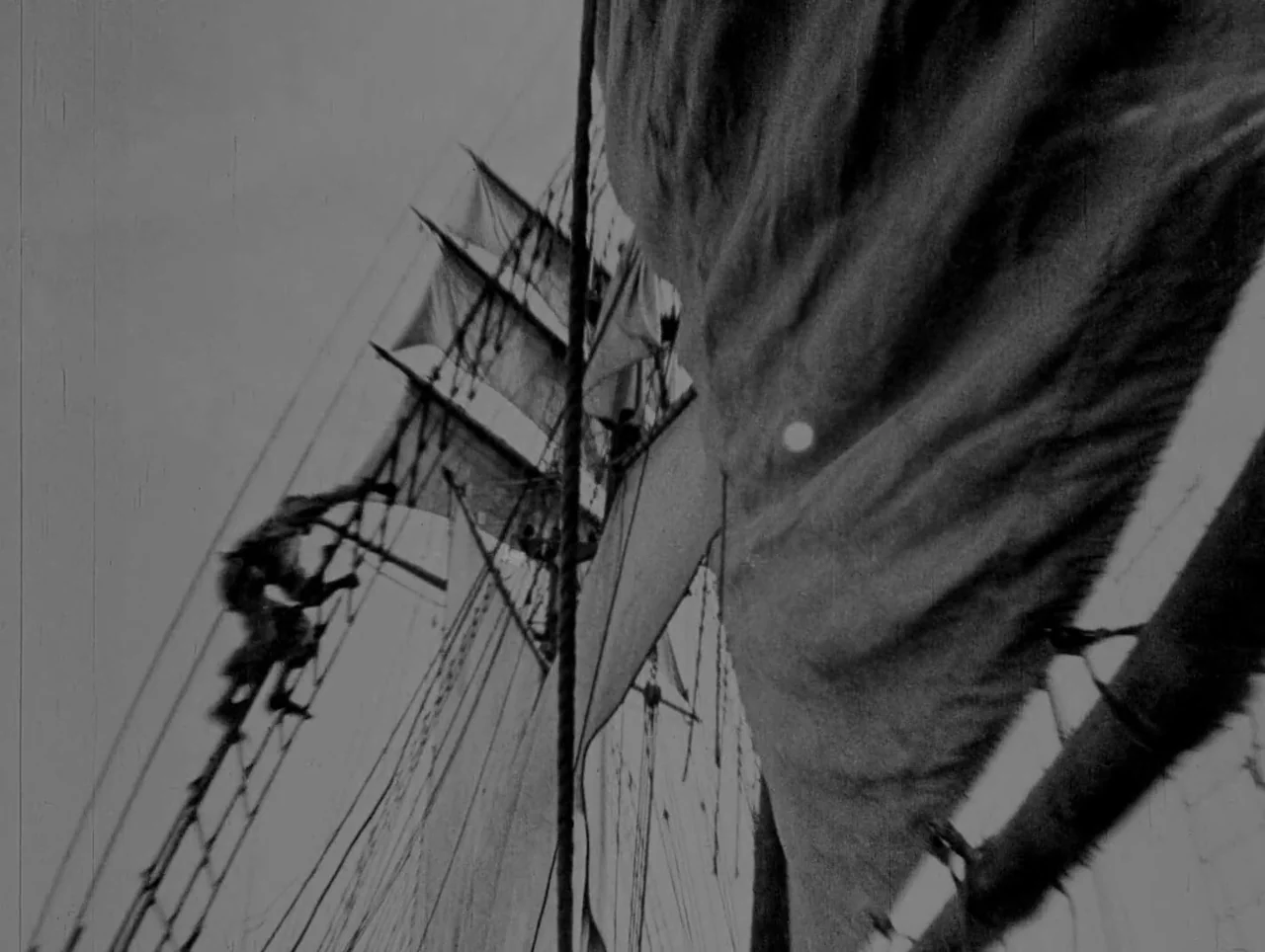 Napoleon (1927) movie still: wide — A tall ship's complex web of ropes and canvas sails occupies the frame. The structure extends from the…