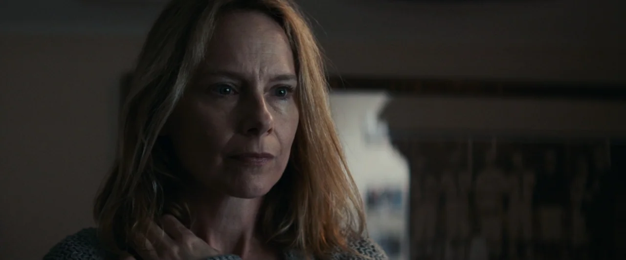 Strange but True (2019) movie still: closeup — A dimly lit residential room features blurred background furniture and soft indoor lighting. A…