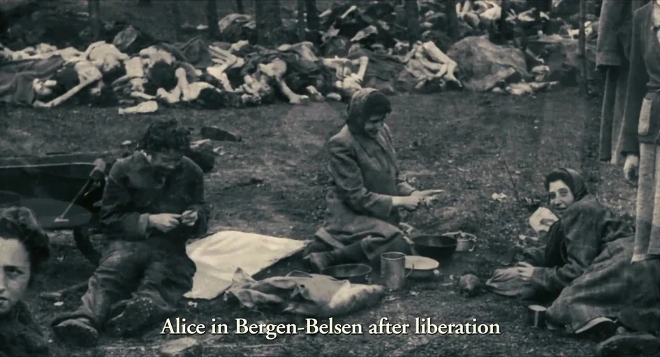 The Last Days (1998) movie still: wide — A desolate clearing at Bergen-Belsen showing groups of survivors near piles of deceased victims. Survivors…