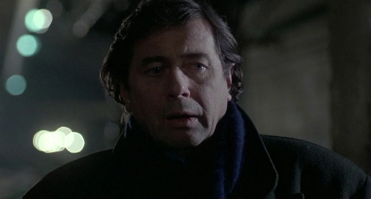 Three Colours: White (1994) movie still: closeup — A dark, dimly lit city street at night serves as the backdrop for the subject. A middle-aged man…