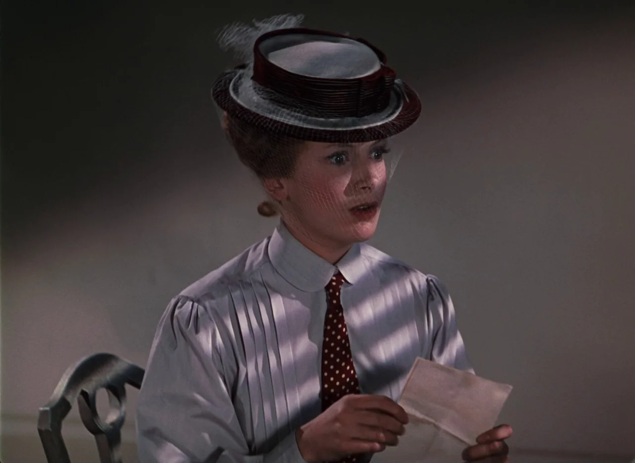 The Life and Death of Colonel Blimp (1943) movie still: medium — A woman wears a 1910s hat and blouse in a sparsely furnished indoor space. She…