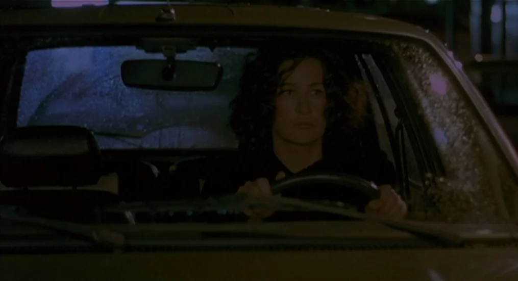 Vendredi Soir (2002) movie still: medium — The interior of a car at night shows a woman driving through rain. Droplets are visible on the windshield…