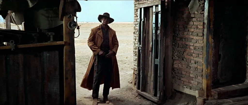 Once Upon A Time In The West (1968) movie still: fullbody — A dilapidated building with unfinished brick walls stands in an arid, vast desert…